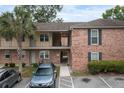 Two-story brick exterior of a building featuring an entryway, balconies, and a well-manicured lawn at 6240 Old Point Rd # C-8, Hanahan, SC 29410