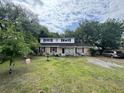 Inviting two-story home with a lush green lawn and mature trees providing ample shade at 759 Powhatan Ave, Mount Pleasant, SC 29464