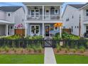 Charming two-story home with a welcoming front porch and a black picket fence at 886 Clay Field Trl, Summerville, SC 29485