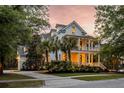 Charming two-story home with double porches, palm trees, and exterior lighting at 11 Dalton St, Daniel Island, SC 29492