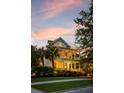 Elegant two-story home with double porches, decorative wreaths, and landscape lighting at 11 Dalton St, Daniel Island, SC 29492