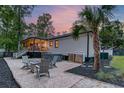 Backyard featuring an outdoor seating area with a fire pit, a hot tub, and a palm tree at 128 Paul Dr, Summerville, SC 29483