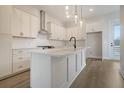 Modern kitchen features white cabinets, a center island with sink, quartz countertops, and stainless steel appliances at 1340 Lucinda St, Mount Pleasant, SC 29466