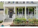 Inviting front porch with a wreath on the front door and colorful flowers in the garden at 149 Daniels Ridge Dr, Summerville, SC 29485
