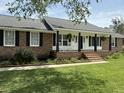 Beautiful brick home featuring a covered front porch, comfortable rocking chairs, and nice landscaping at 1606 Waterside Blvd, Moncks Corner, SC 29461