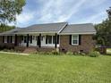 Welcoming single story brick home with a lovely porch, rocking chairs and a well-maintained lawn at 1606 Waterside Blvd, Moncks Corner, SC 29461