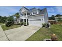 Charming two-story home with a front balcony, attached garage, and concrete driveway at 203 Yeamans Way, Summerville, SC 29483