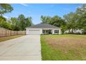 Inviting single-story house with a manicured front yard, long driveway, and a welcoming entrance with black shutters at 204 Read St, Moncks Corner, SC 29461