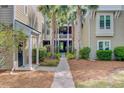 Welcoming pathway between buildings, framed by palm trees and lush landscaping at 2121 Egret Crest Ln, Charleston, SC 29414