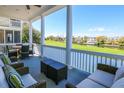 Relaxing covered porch with comfortable seating overlooking a serene golf course at 25 Ocean Point Dr, Isle of Palms, SC 29451