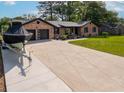 Expansive driveway leading to a brick home with a two-car garage and lush green lawn at 2864 Wofford Rd, Charleston, SC 29414