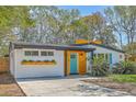 Inviting home with a turquoise front door, wooden accents, and a lush green lawn at 32 Briarcliff Dr, Charleston, SC 29407