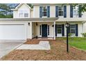 Inviting entryway of a two-story home with a white garage door and dark blue door at 332 Damascus Dr, Summerville, SC 29483