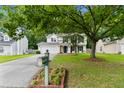Charming two-story home showcasing a well-maintained lawn, mature trees, and inviting curb appeal at 332 Damascus Dr, Summerville, SC 29483