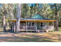 Charming exterior of a green cottage-style home surrounded by mature trees at 3360 Baldwin Ln, Green Pond, SC 29446