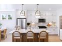 Stylish kitchen with white cabinets, a stainless steel refrigerator, and an island with barstool seating at 353 Claret Cup Way, Charleston, SC 29414
