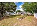 Spacious backyard featuring an adjacent garden, lush trees, and a waterfront at 3948 Gift Blvd, Johns Island, SC 29455