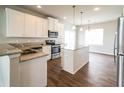 Bright kitchen with stainless steel appliances, an island, granite countertops and hardwood floors at 4021 Sanderson Ln, Summerville, SC 29483