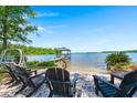 Enjoy lakeside relaxation with Adirondack chairs and a covered dock at 423 Lake Moultrie Dr, Bonneau, SC 29431