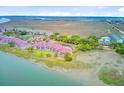 Aerial view of the complex and surroundings, showing the water, marsh and neighborhood at 5 Mariners Cay Dr, Folly Beach, SC 29439