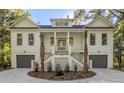 Traditional home exterior with double garages, a welcoming staircase, and tasteful landscaping at 5105 St George Ln, Hollywood, SC 29449