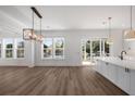 Sunlit open concept living area with wood floors and multiple large windows at 6518 Beagle Club Rd, Meggett, SC 29449