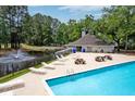 Relaxing pool area with lounge chairs, picnic tables, pond and mature trees at 7955 Timbercreek Ln # 1807, North Charleston, SC 29418