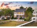 Charming home with lush landscaping, a pool, a walkway to water, and stunning sunset at 80 On The Harbor Dr, Mount Pleasant, SC 29464