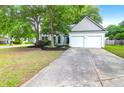 Inviting home with mature trees, a driveway, and a two-car garage, offering a blend of comfort and curb appeal at 8451 Walsham St, North Charleston, SC 29420
