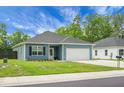 Well-kept single-story home with blue siding, a two-car garage, and lush green lawn at 8703 Jenny Lind St, North Charleston, SC 29406