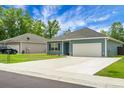 Attractive single-story home with blue siding, an attached garage, and extended driveway at 8703 Jenny Lind St, North Charleston, SC 29406