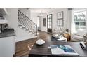 Inviting living room featuring hardwood floors, natural light, and a modern staircase with iron railings at 000 Remington Trl, Johns Island, SC 29455
