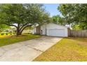 Front exterior of a charming single-story home featuring a long driveway, garage and a well-manicured lawn at 1024 Willowood Ave, Goose Creek, SC 29445