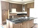 Spacious kitchen featuring an island with dark stone countertops and wooden cabinets at 120 Shingle Oak Dr, Moncks Corner, SC 29461