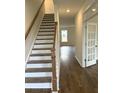Bright foyer featuring a staircase with wood handrail and hardwood floors at 120 Shingle Oak Dr, Moncks Corner, SC 29461