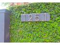 Close-up of house number on brick wall covered in ivy at 1251 Charlestowne Dr, Charleston, SC 29407