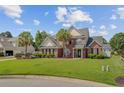 Charming brick home featuring a manicured lawn, decorative landscaping, and picturesque neighborhood setting at 1503 Pondside Ct, Summerville, SC 29485