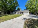 White single-story home with a long driveway leading to an attached one-car garage and manicured lawn at 1534 Kentwood Cir, Charleston, SC 29412