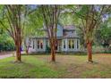 Two-story home with light blue siding, bay windows, mature landscaping, and tall crepe myrtle trees at 1830 Kempton Ave, James Island, SC 29412