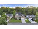 An aerial view showcases this two-story brick home with an attached garage, mature trees and a large lawn at 1901 Bairds Cv, Charleston, SC 29414