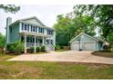 Two-story home with detached garage and basketball hoop; spacious driveway at 1976 Liberia Rd, Wadmalaw Island, SC 29487
