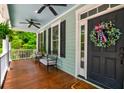 Inviting front porch with comfortable seating and a ceiling fan at 1976 Liberia Rd, Wadmalaw Island, SC 29487