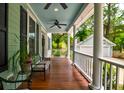 Inviting front porch with ceiling fans, potted plants and seating at 1976 Liberia Rd, Wadmalaw Island, SC 29487