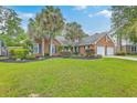 Beautiful brick home with blue shutters, a two-car garage, and well-maintained lawn and landscaping at 2120 Fife Ln, Charleston, SC 29414