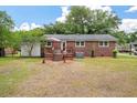 Backyard view featuring a small wooden deck, a brick exterior, and a well-maintained lawn at 2220 Pinehurst Ave, Charleston, SC 29414