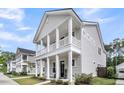 Beautiful two-story home featuring a double porch with white columns and well-maintained landscaping at 2844 Pinelog Ln, Johns Island, SC 29455