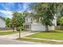 Home exterior features a well-kept lawn, a cozy front porch, and an attached two-car garage at 300 Greens Ct, Goose Creek, SC 29445