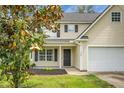 Inviting home exterior with landscaped yard, covered porch, and attached garage on a sunny day at 300 Greens Ct, Goose Creek, SC 29445