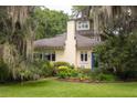 Inviting facade with manicured lawn and beautiful landscaping surrounding a charming home with a blue front door at 34 Formosa Dr, Charleston, SC 29407