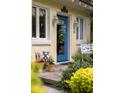 Close-up of a blue front door flanked by windows, planters and vintage decor for inviting curb appeal at 34 Formosa Dr, Charleston, SC 29407